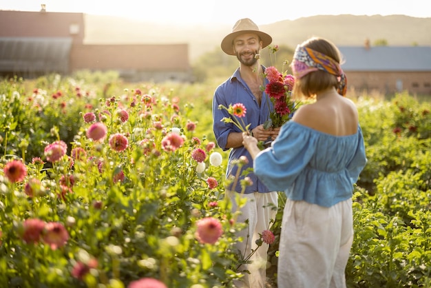 L'uomo e la donna raccolgono i fiori in una fattoria all'aperto