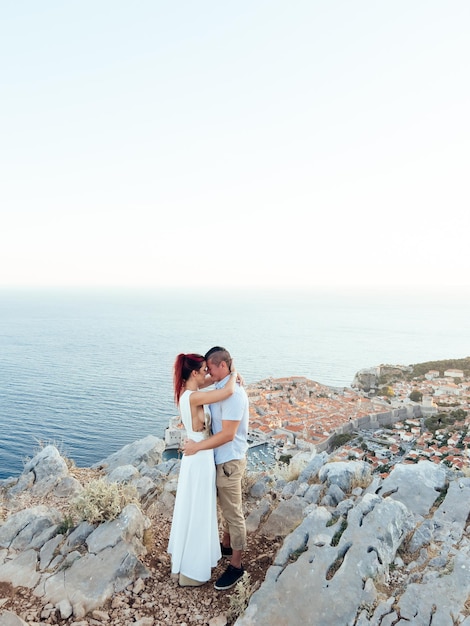 L'uomo e la donna si abbracciano su una roccia sopra la vecchia budva montenegro