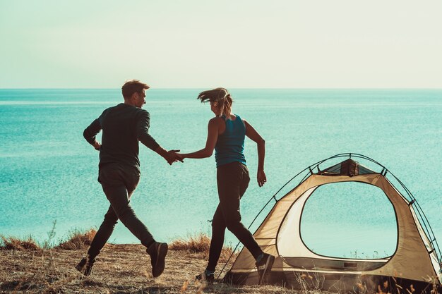 L'uomo e la donna si divertono nel campeggio vicino al mare