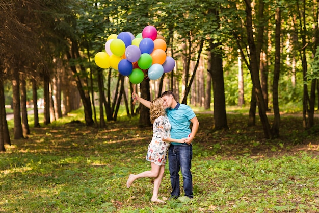 L'uomo e la moglie incinta con palloncini all'aperto
