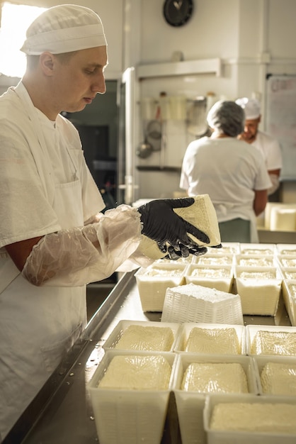 L'uomo è un casaro in procinto di produrre diverse varietà di formaggio nell'industria Latte caseario