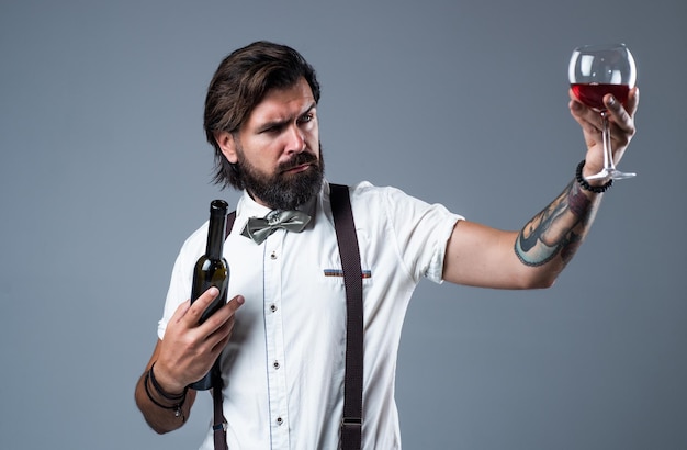 L'uomo elegante e brutale in abiti formali ha curato i capelli bevendo un'azienda vinicola