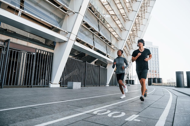 L'uomo europeo e la donna afroamericana in abiti sportivi si allenano insieme