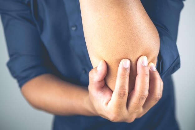 L'uomo fa male al gomito Questi sintomi possono essere causati da un duro lavoro sportivo con il braccio Inquadratura ravvicinata