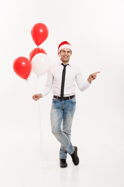 L&#39;uomo felice bello di affari che cammina con il pallone rosso celebra il natale