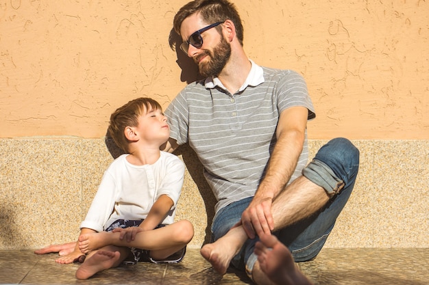 L'uomo felice e il figlio siedono vicino alla casa