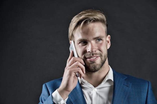 L'uomo felice parla sullo smartphone Uomo d'affari sorriso con il telefono cellulare Concetto di stile di vita aziendale Comunicazione aziendale e nuova tecnologia vintage