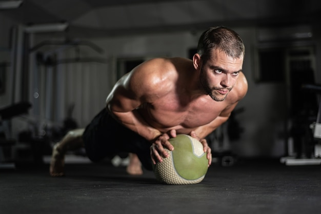 L'uomo fitness fa flessioni sulla palla