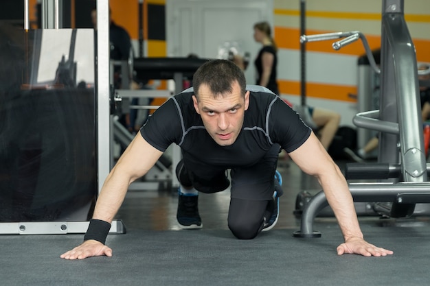 L'uomo fitness facendo flessioni esercita un allenamento intenso in palestra.