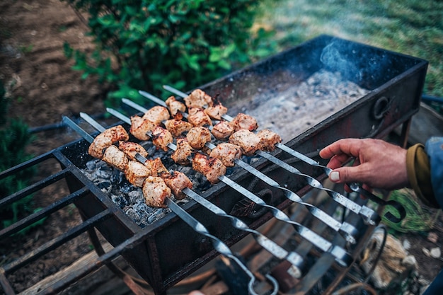 L'uomo frigge kebab alla griglia in cortile