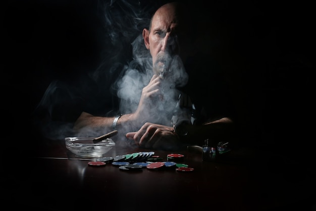 L'uomo fuma la pipa e gioca a poker