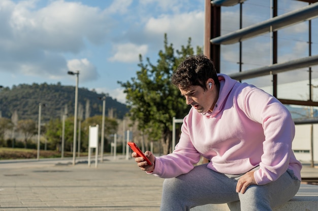 L'uomo grasso indossa felpa rosa e pantaloni della tuta, cielo blu con nuvole