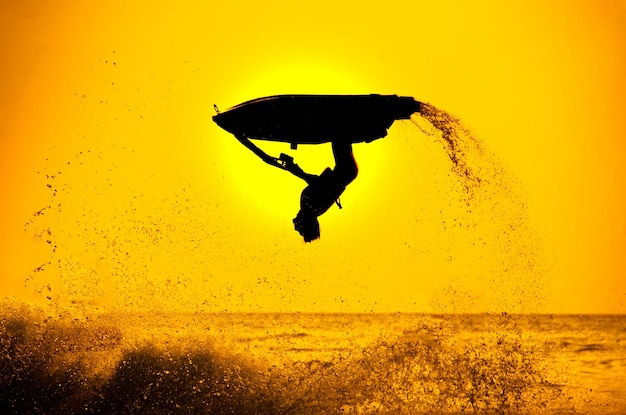 L'uomo guida il jet ski freestyle al tramonto