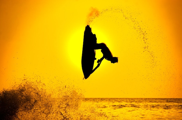 L'uomo guida il jet ski freestyle al tramonto