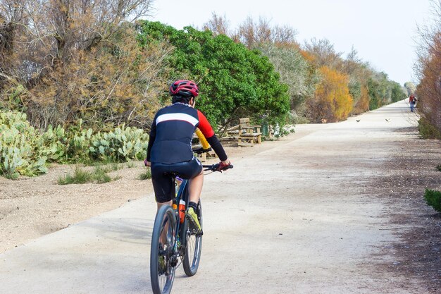 L'uomo guida una bicicletta in campagna Stile di vita sano