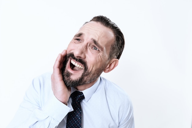 L&#39;uomo ha un mal di denti. Tiene le mani alla mascella.