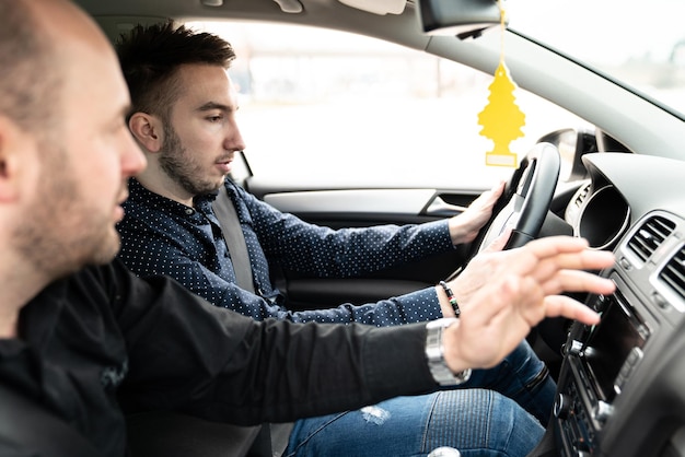 L'uomo impara a guidare in macchina con l'istruttore