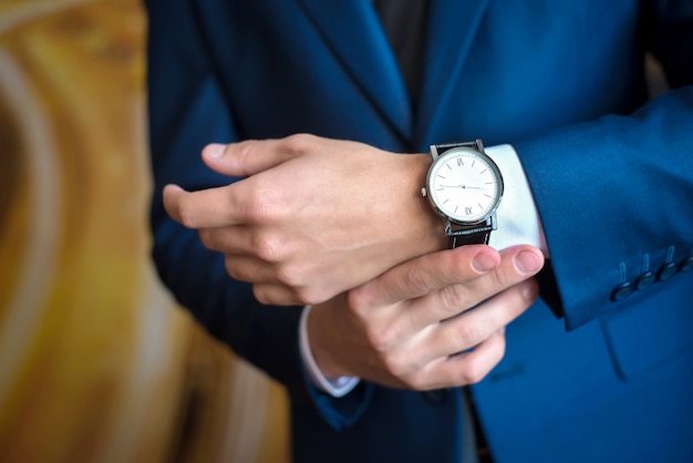 L'uomo in abito blu guarda l'orologio