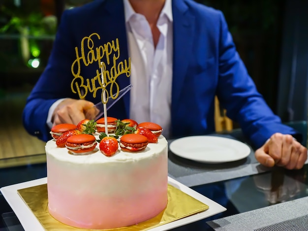 L&#39;uomo in blu navy prepara il taglio della torta di compleanno