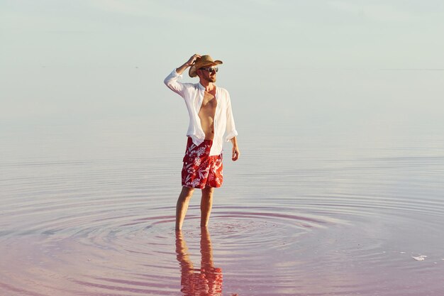 L'uomo in cappello e abiti casual cammina sul lago all'isola di Jarilgach in Ucraina