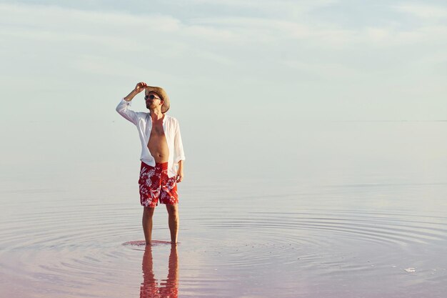 L'uomo in cappello e abiti casual cammina sul lago all'isola di Jarilgach in Ucraina
