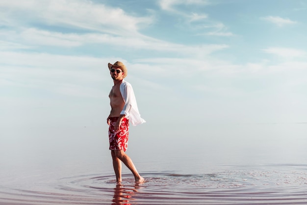 L'uomo in cappello e abiti casual cammina sul lago all'isola di Jarilgach in Ucraina