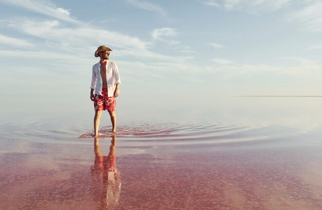 L'uomo in cappello e abiti casual cammina sul lago all'isola di Jarilgach in Ucraina