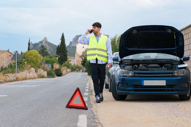 L'uomo in giubbotto catarifrangente effettua una telefonata dopo un incidente stradale