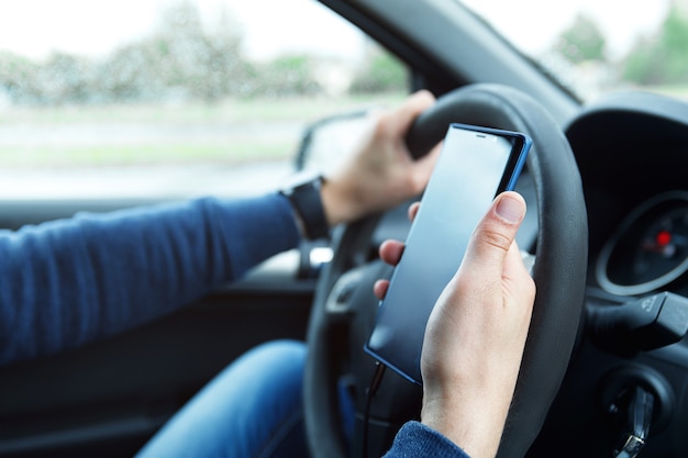L'uomo in macchina utilizza lo smartphone. Concetti di condivisione del viaggio, sicurezza di guida o navigazione GPS.