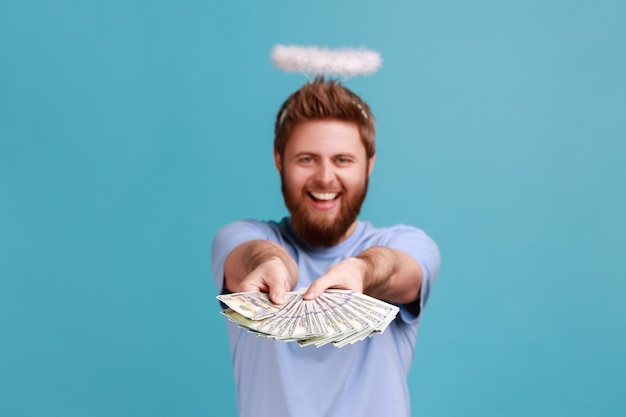 L'uomo in maglietta blu che porge il grande fan delle banconote del dollaro vince la lotteria