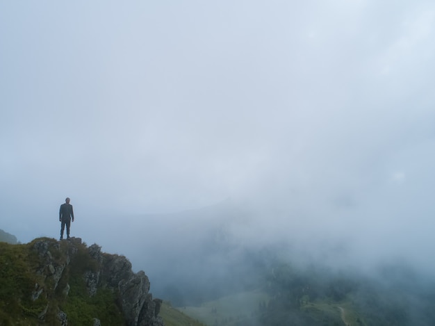 L'uomo in piedi sulla montagna nebbiosa