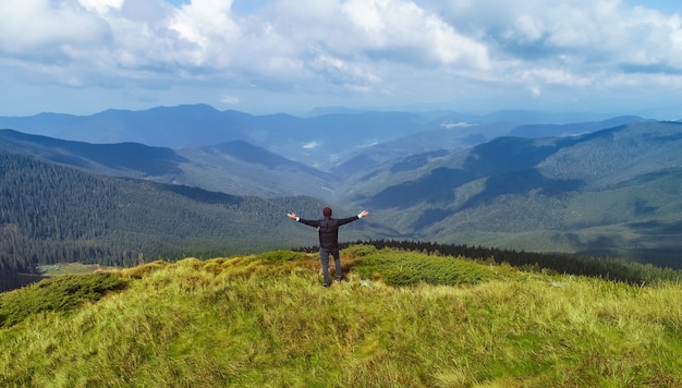 L'uomo in piedi sullo sfondo pittoresco delle montagne