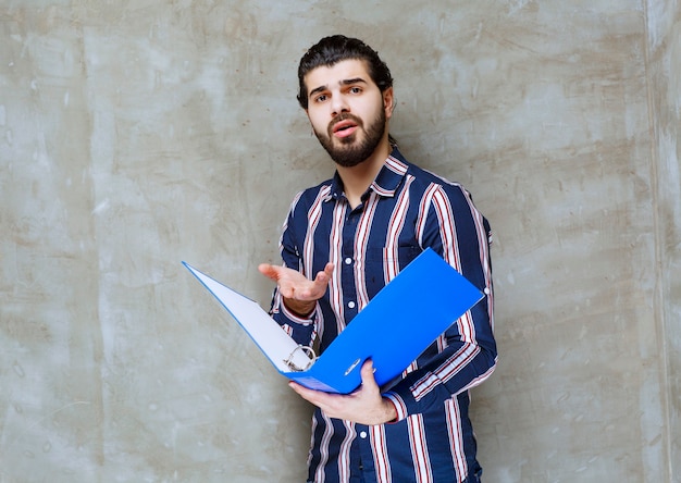 L'uomo in possesso di una cartella blu e sembra insoddisfatto.