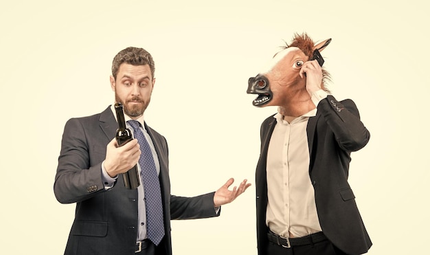 L'uomo in testa di cavallo parla al telefono mentre il manager beve vino celebrando la celebrazione della festa aziendale