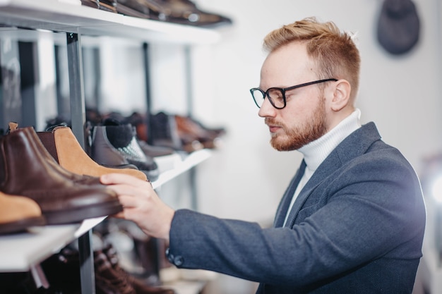 l'uomo in un negozio di scarpe compra le scarpe