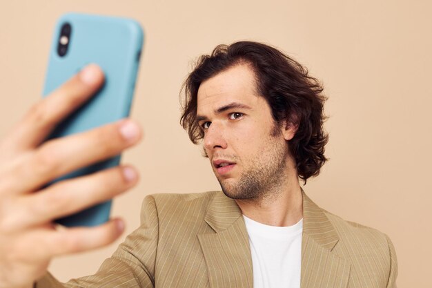 L'uomo in un vestito che posa emozioni guardando il telefono ha isolato lo sfondo