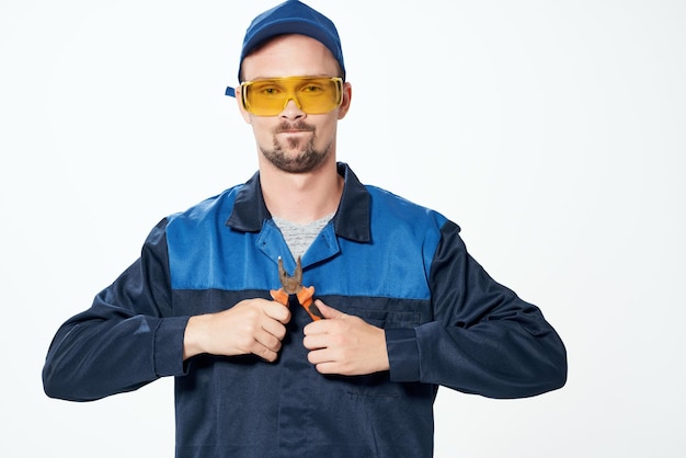 L'uomo in uniforme da costruzione le pinze riparano i professionisti dell'edilizia