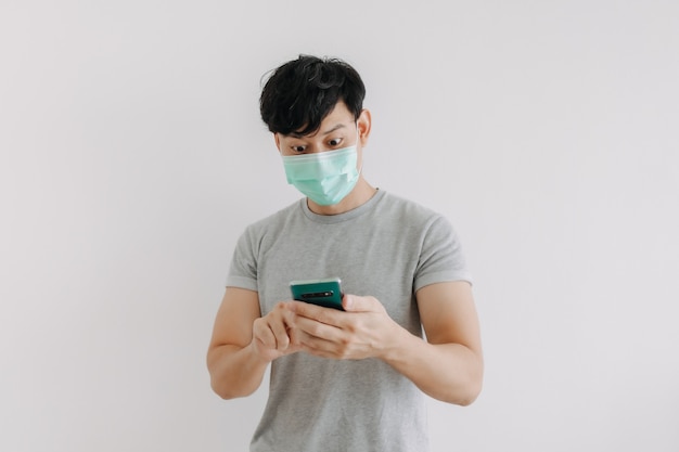 L'uomo indossa la maschera e utilizza l'applicazione telefonica isolata su sfondo bianco white