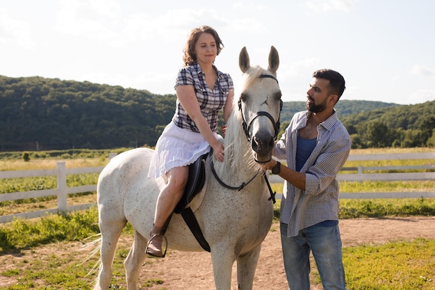 L'uomo insegna a una donna ad andare a cavallo