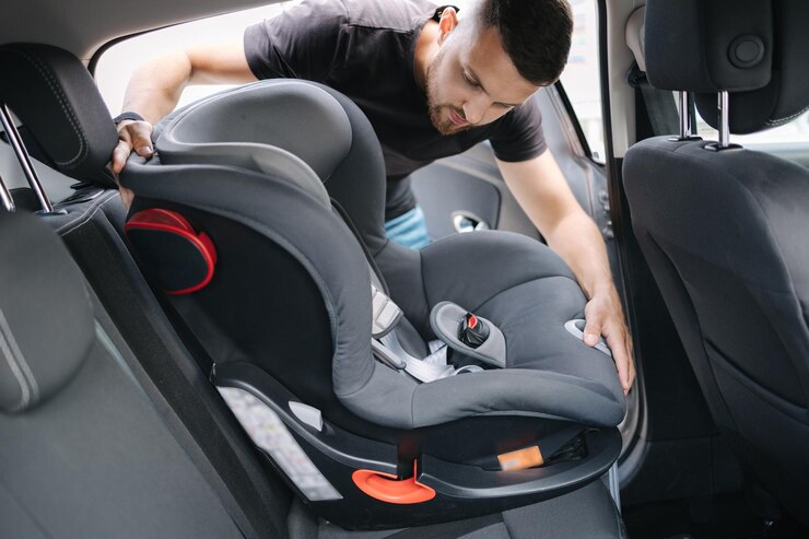 L'uomo installa un seggiolino per bambini in auto sul sedile posteriore del padre responsabile ha pensato alla sicurezza di