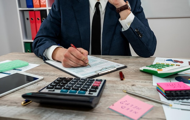 L'uomo lavora con il modulo fiscale tempo per le tasse