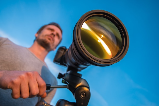 L'uomo lavora con la fotocamera sul treppiede