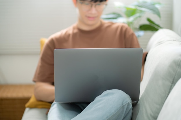 L'uomo lavora da casa lavora online sul laptop Uomo d'affari asiatico che lavora online concetto di business