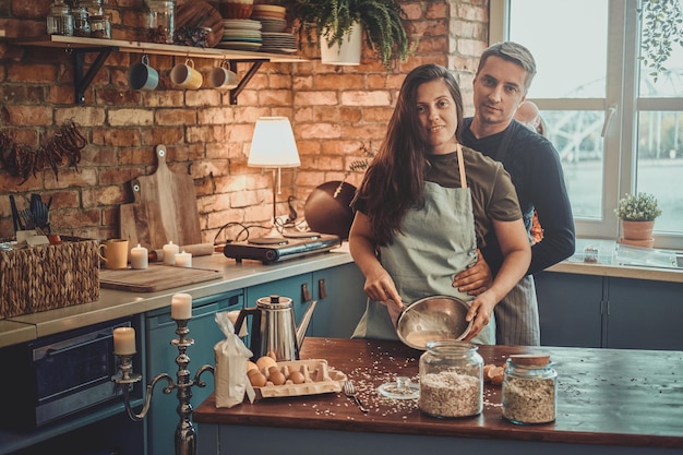 L'uomo maturo attraente sta trascorrendo la mattinata con sua moglie in cucina.