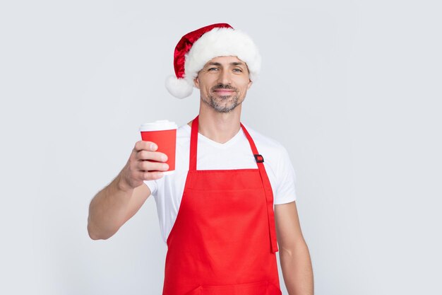 l'uomo maturo di Natale con il cappello rosso di Babbo Natale e il grembiule tengono la tazza di caffè