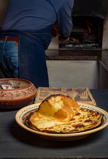 L'uomo mette la padella con le frittelle nel forno