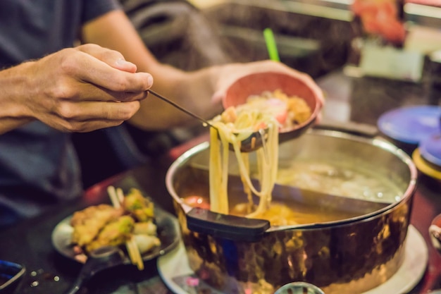 L'uomo mette la zuppa in un piatto