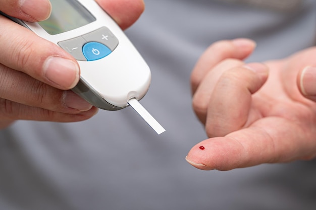 L'uomo misura il suo concetto di diabete del test del campione di sangue del glucometro