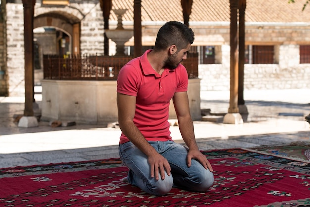 L'uomo musulmano sta pregando nella moschea all'aperto