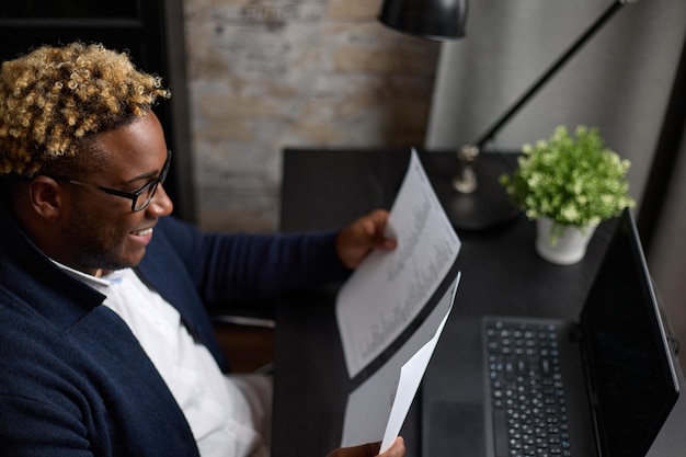 L'uomo nero moderno con un'acconciatura afro studia i piani in ufficio